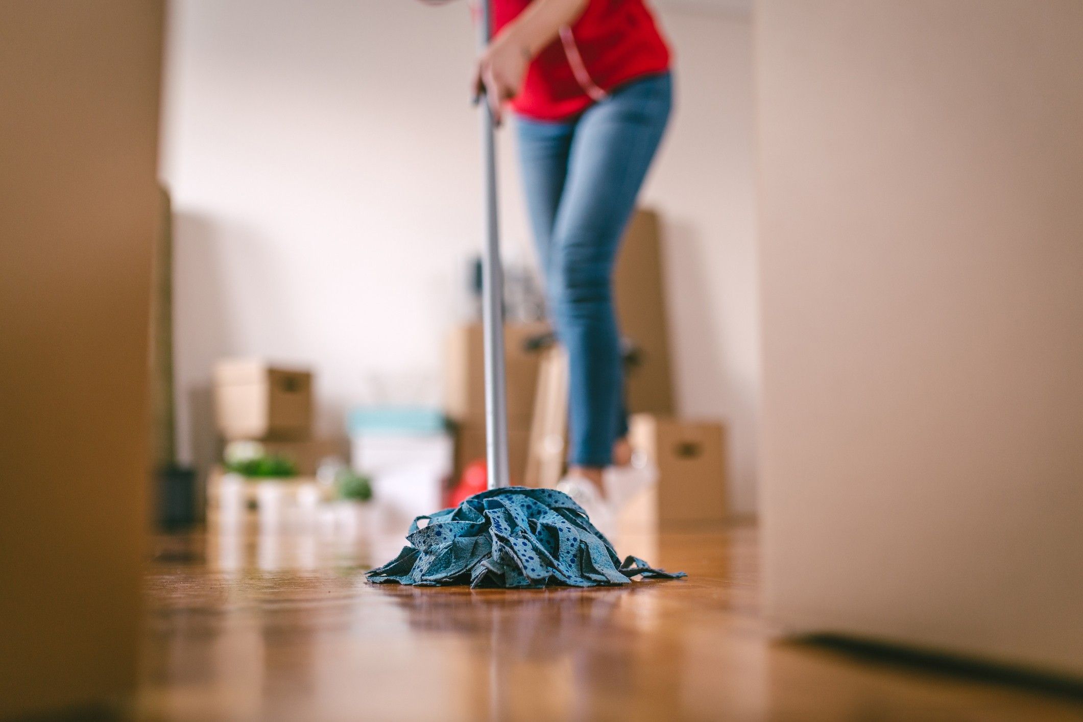 A close up of a woman mopping the floor.