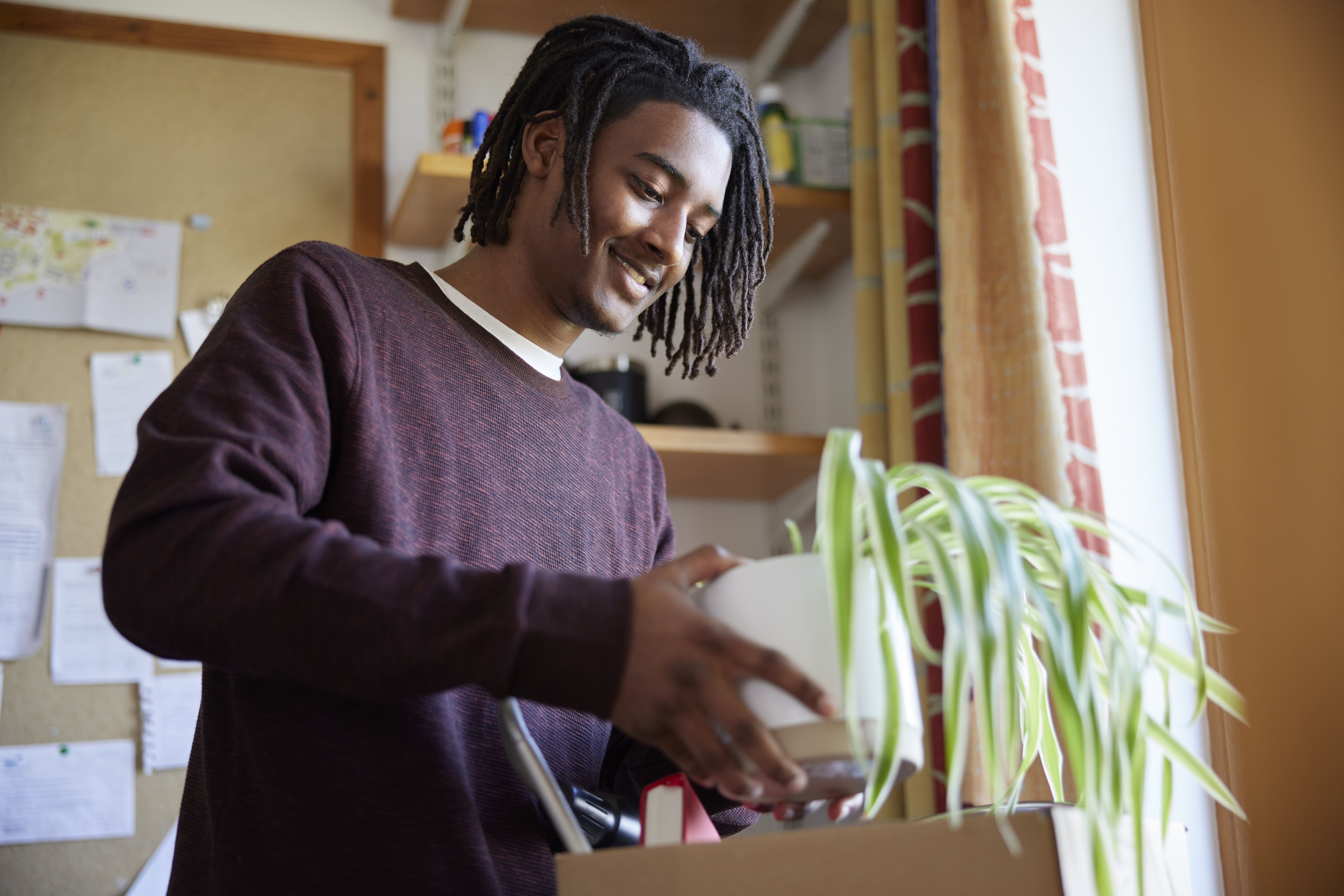 A college student packs items into a box.