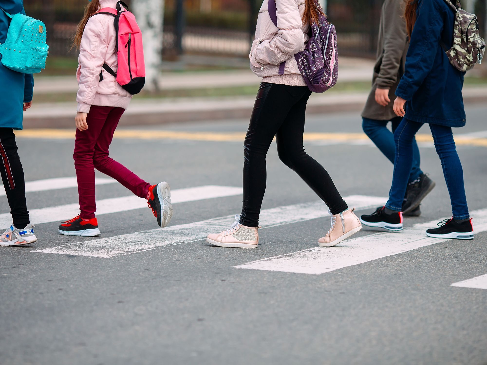 A group of kids with backpacks cross the street on the way to school.