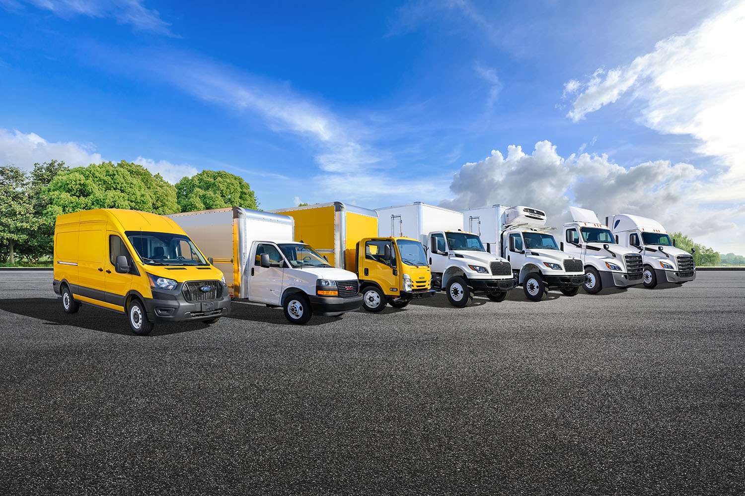 A line of Penske trucks - from cargo van to semi-truck - parked in a lot.