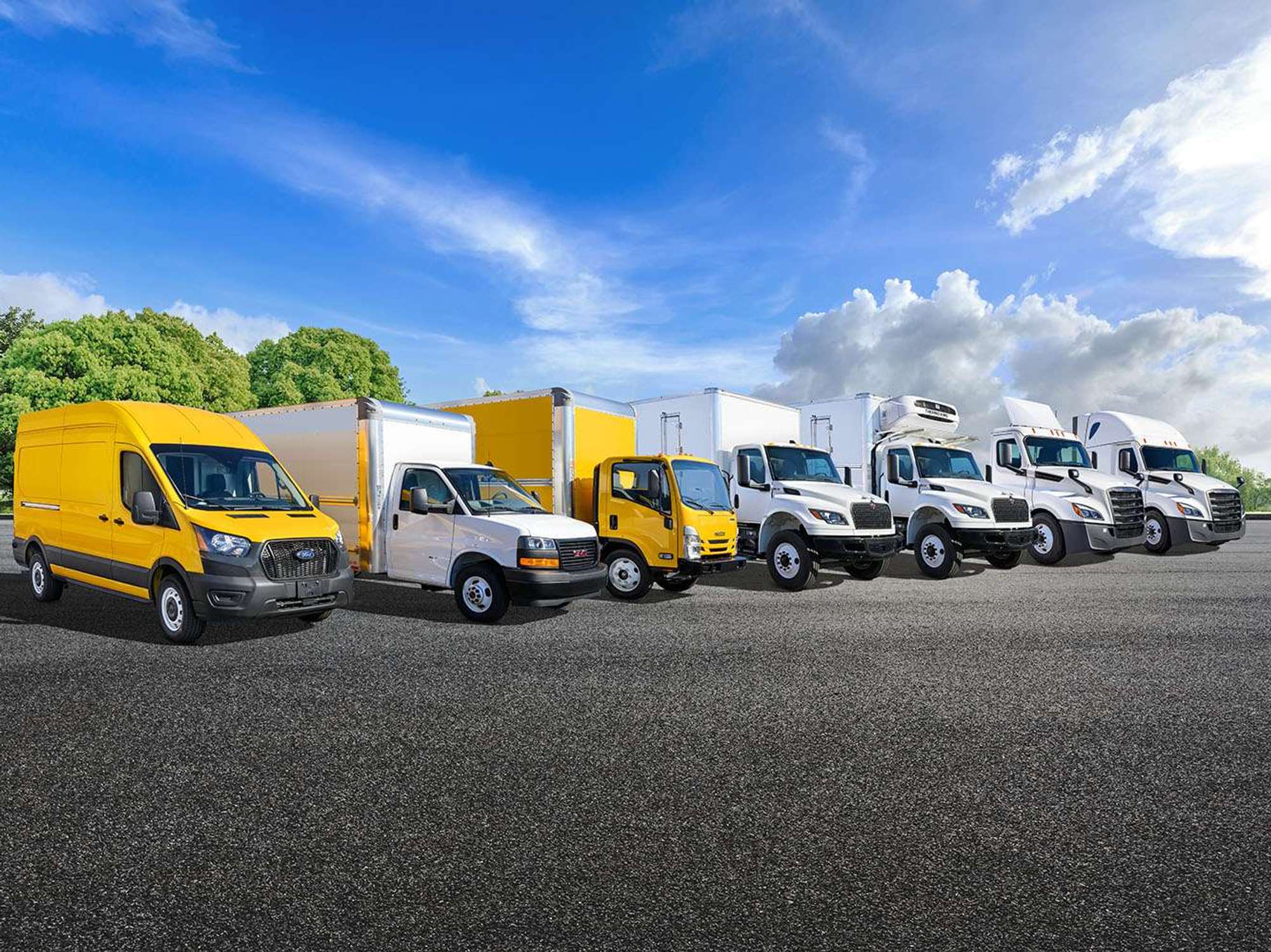 A line of Penske trucks - from cargo van to semi-truck - parked in a lot.