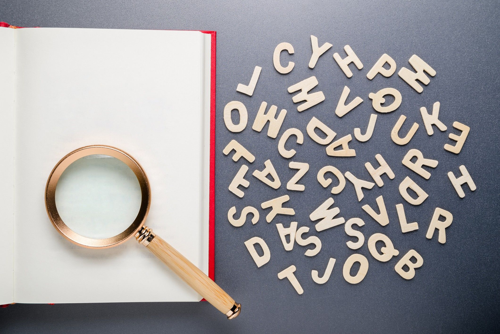 A magnifying glass and random wooden letters. 