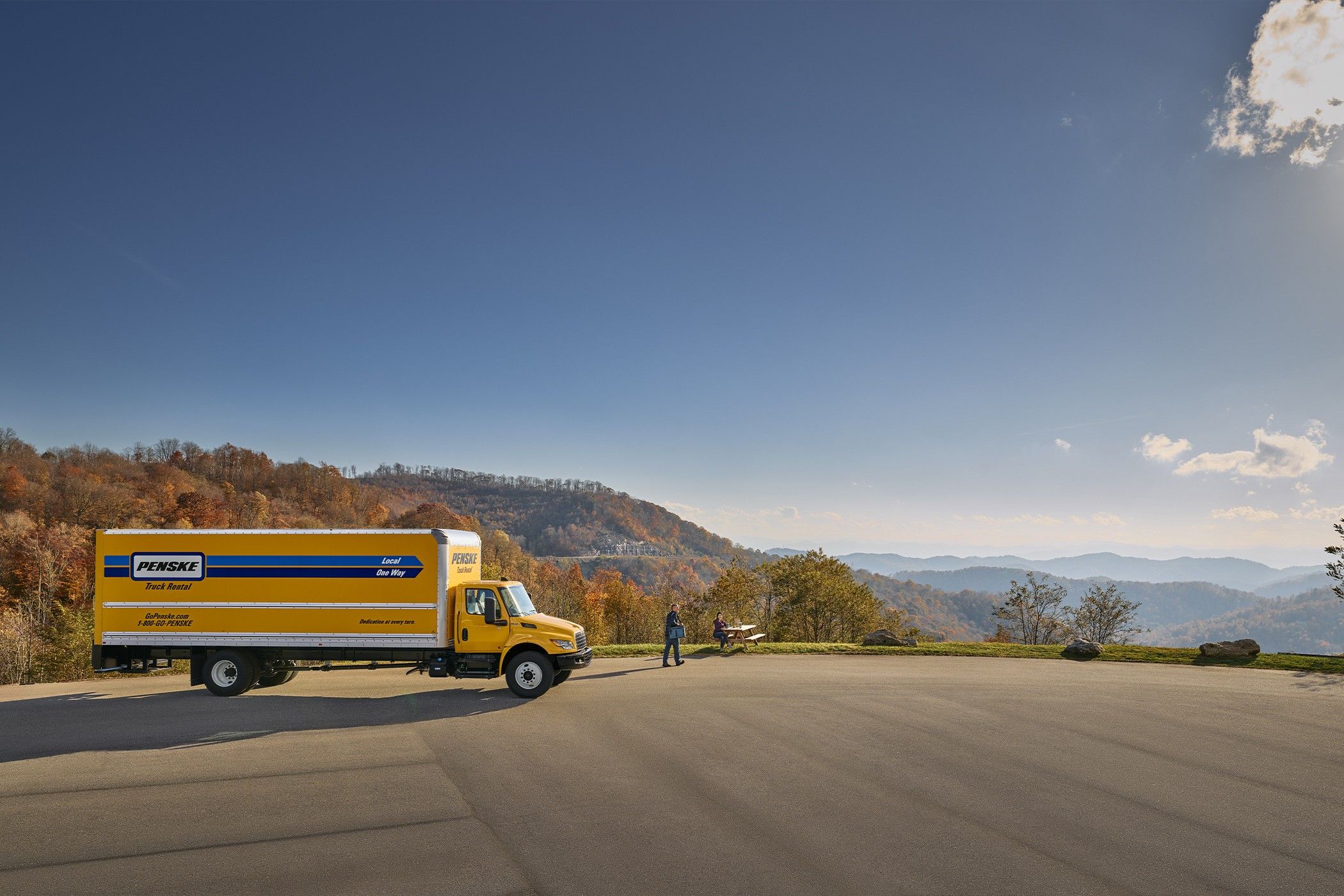 A parked yellow Penske truck in the mountains.