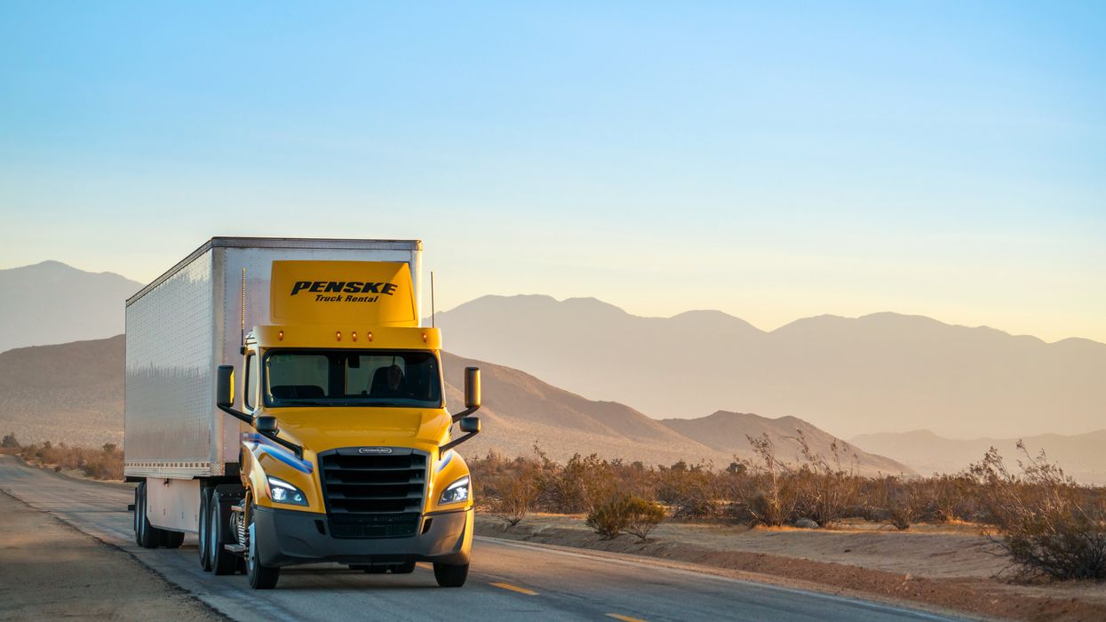 A Penske Tandem-Axle Day Cab drives on a high-desert road.