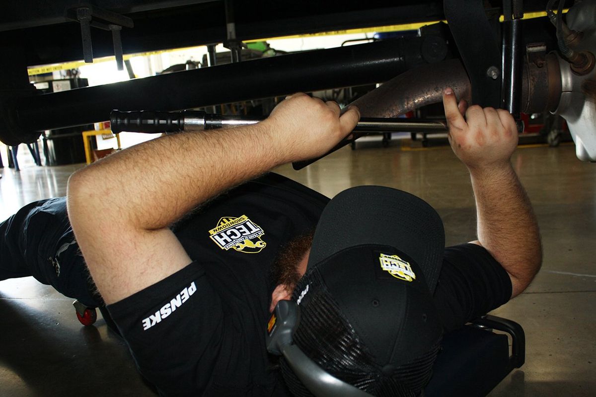 A Penske technician performs a hands-on inspection as part of the 2025 Tech Showdown competition.