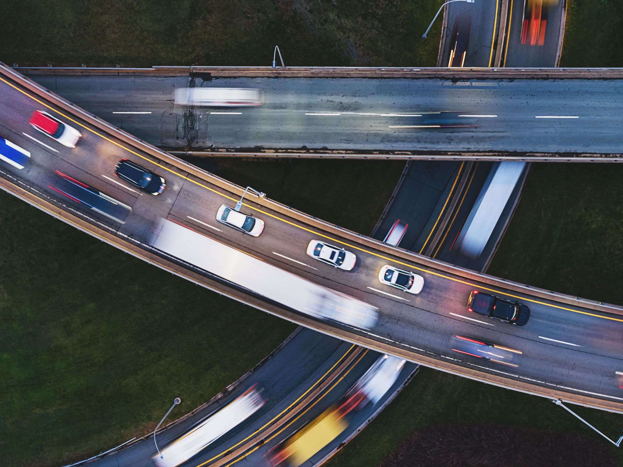 A photo from above of traffic moving quickly on three intersecting highways.