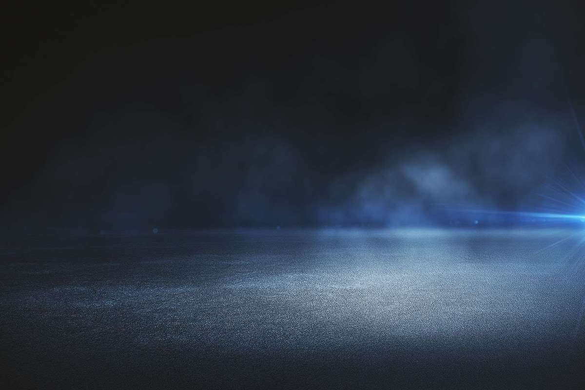 A rainy road with headlights in the distance.