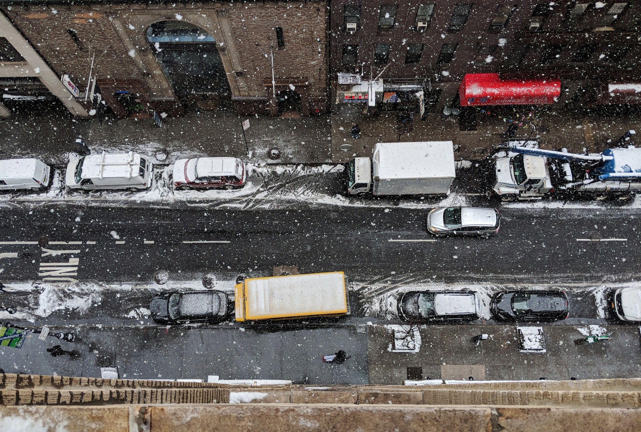 A snowy city street congested with traffic.