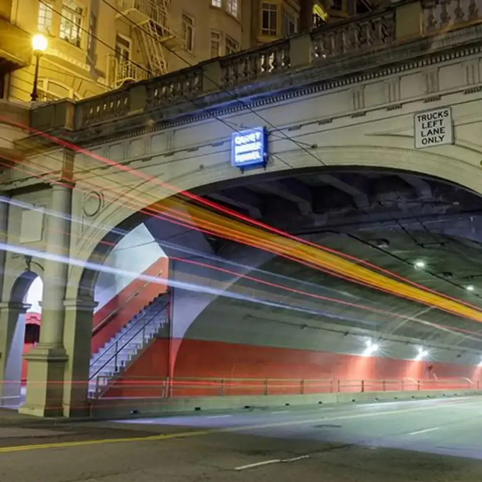 A tunnel at night with lights streaks going through it.
