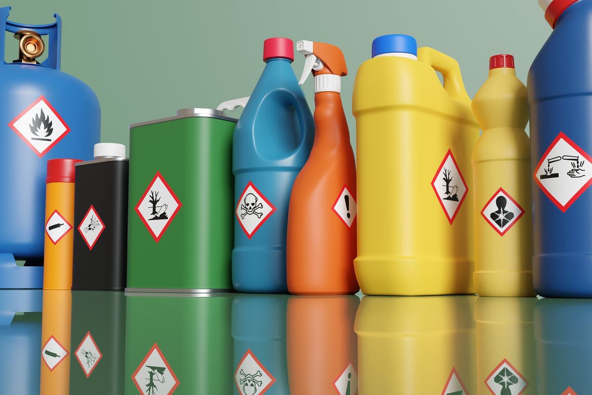 Assorted bottles and propane tanks with hazardous materials labeling on each.