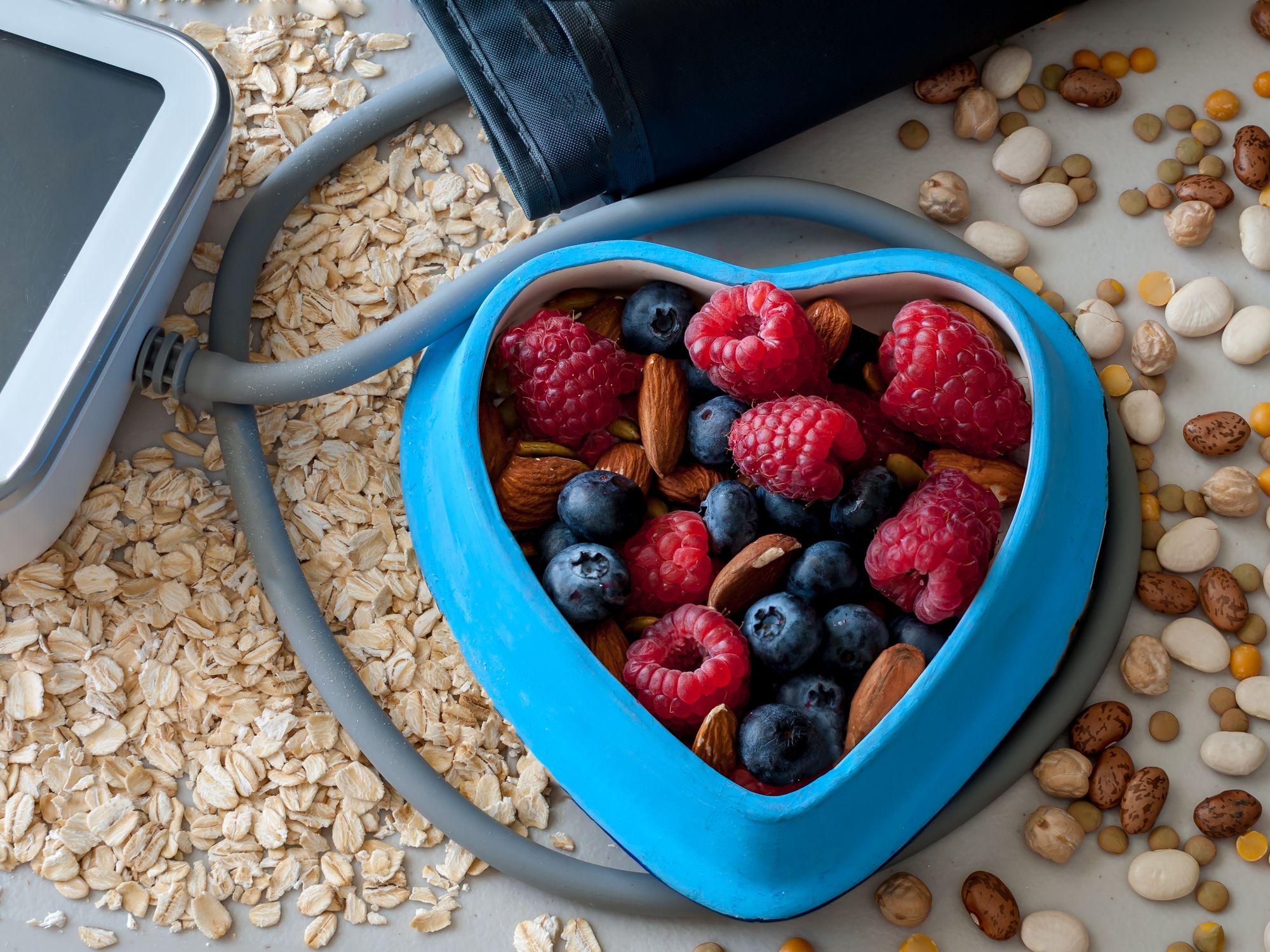 Berries in a blue heart shaped bowl and blood pressure cuff.