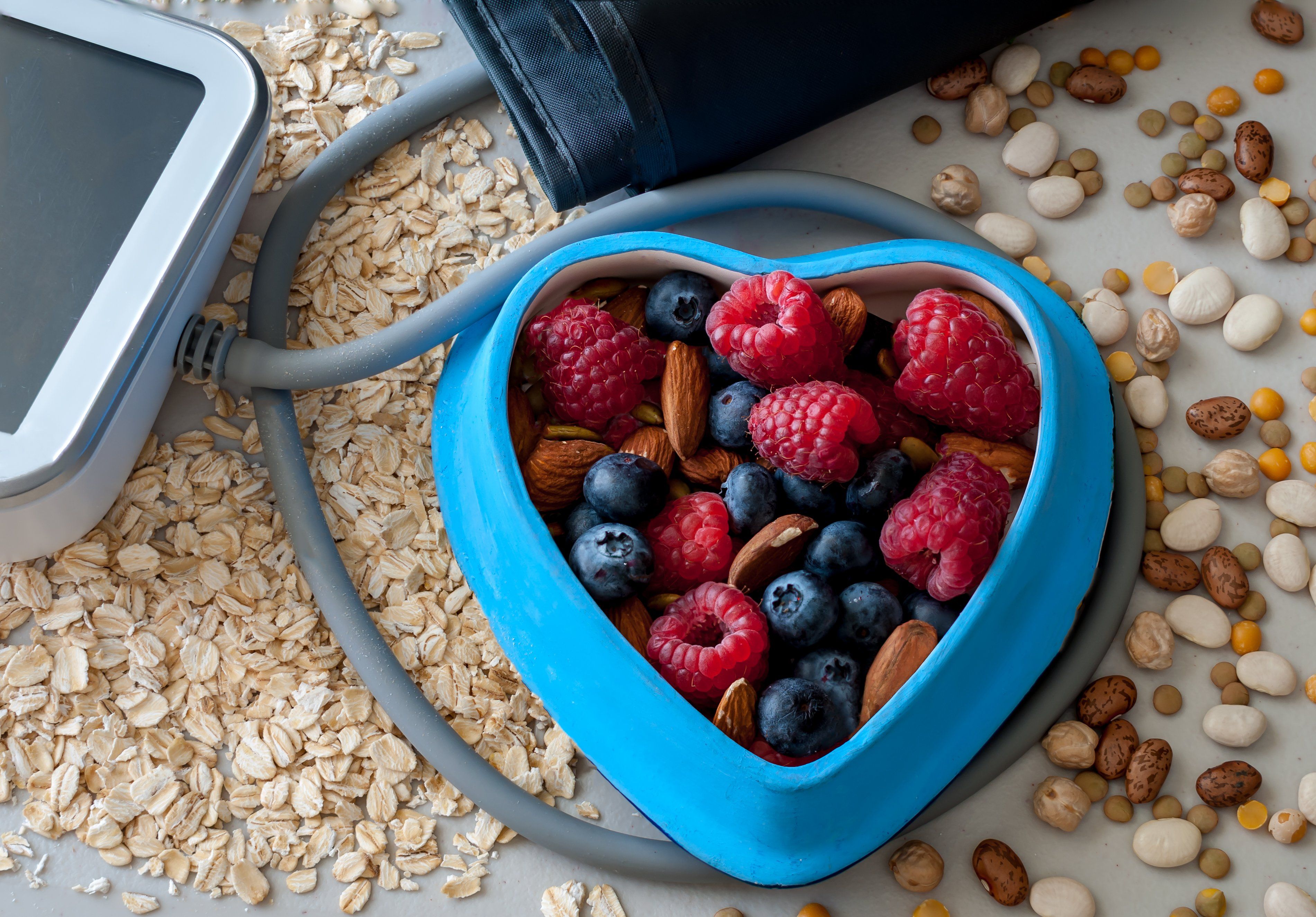 Berries in a blue heart shaped bowl and blood pressure cuff.