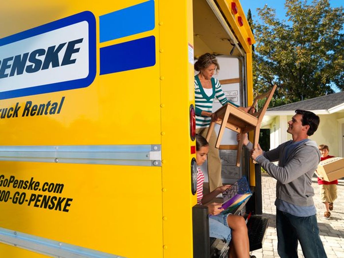 Family loading a Penske moving truck