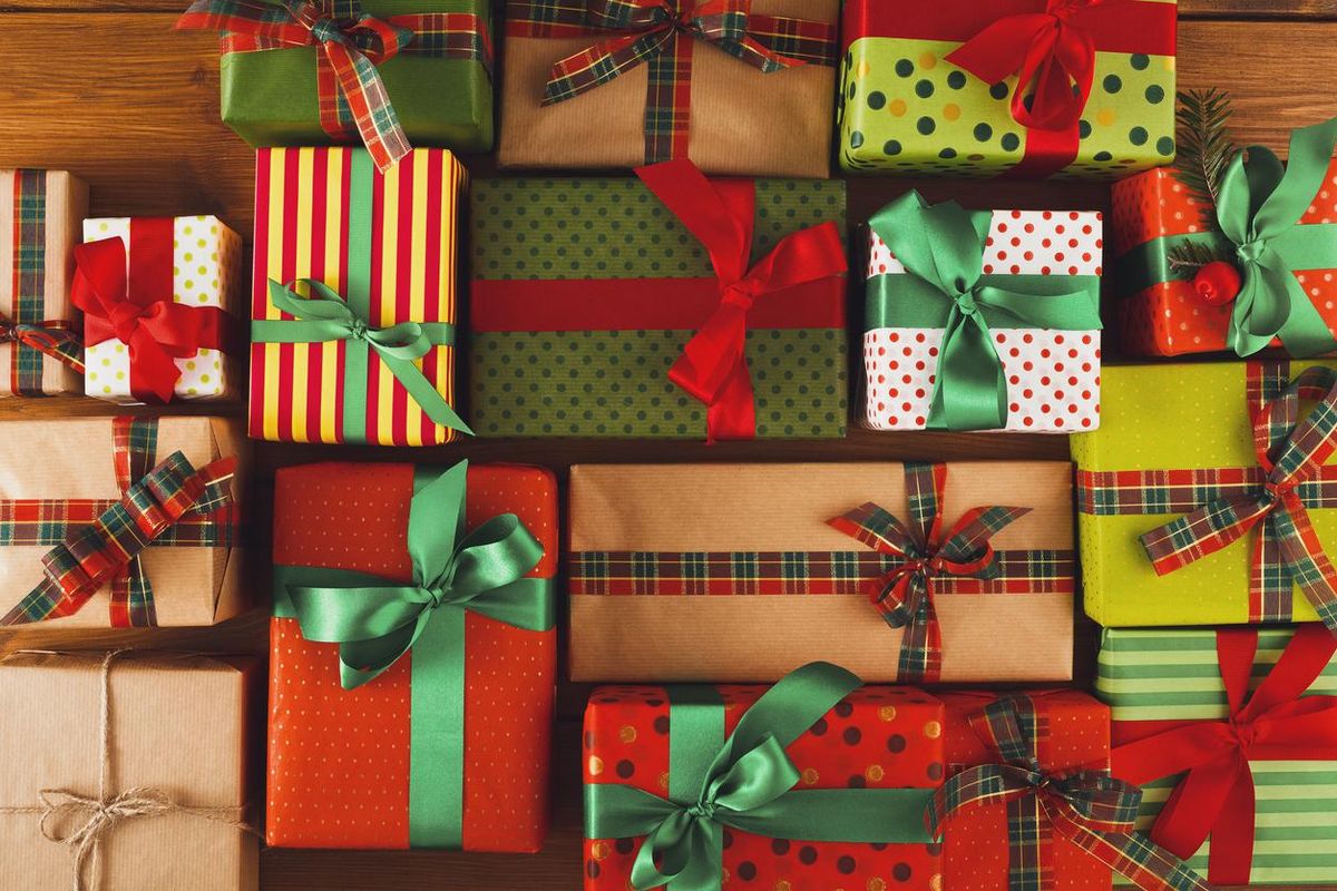 Festively wrapped gifts with colorful ribbons in various patterns on a wooden surface.