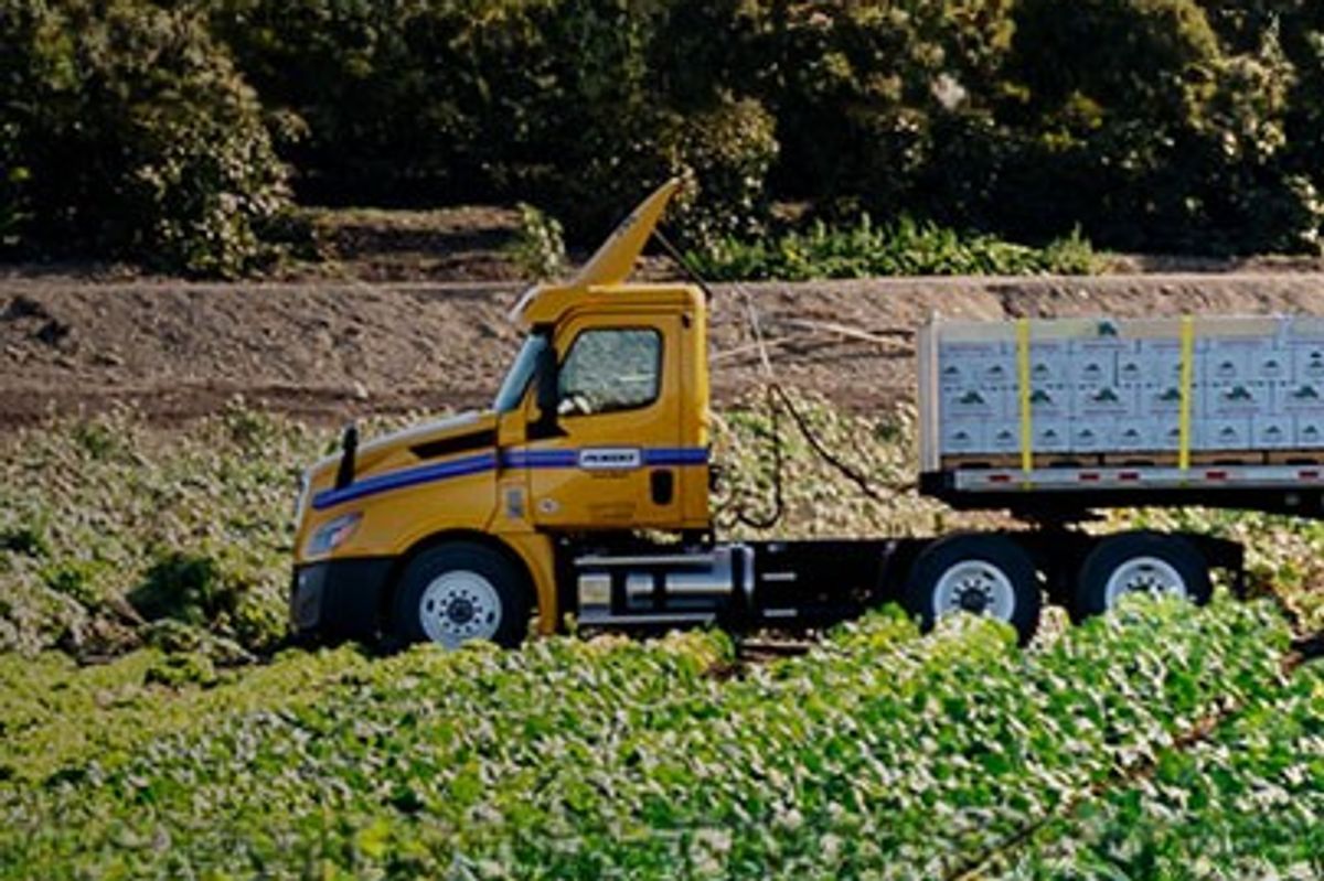 Flatbed trailer hauling items through a farm