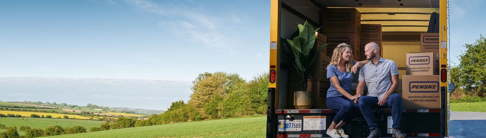 Happy couple with their moving truck rental