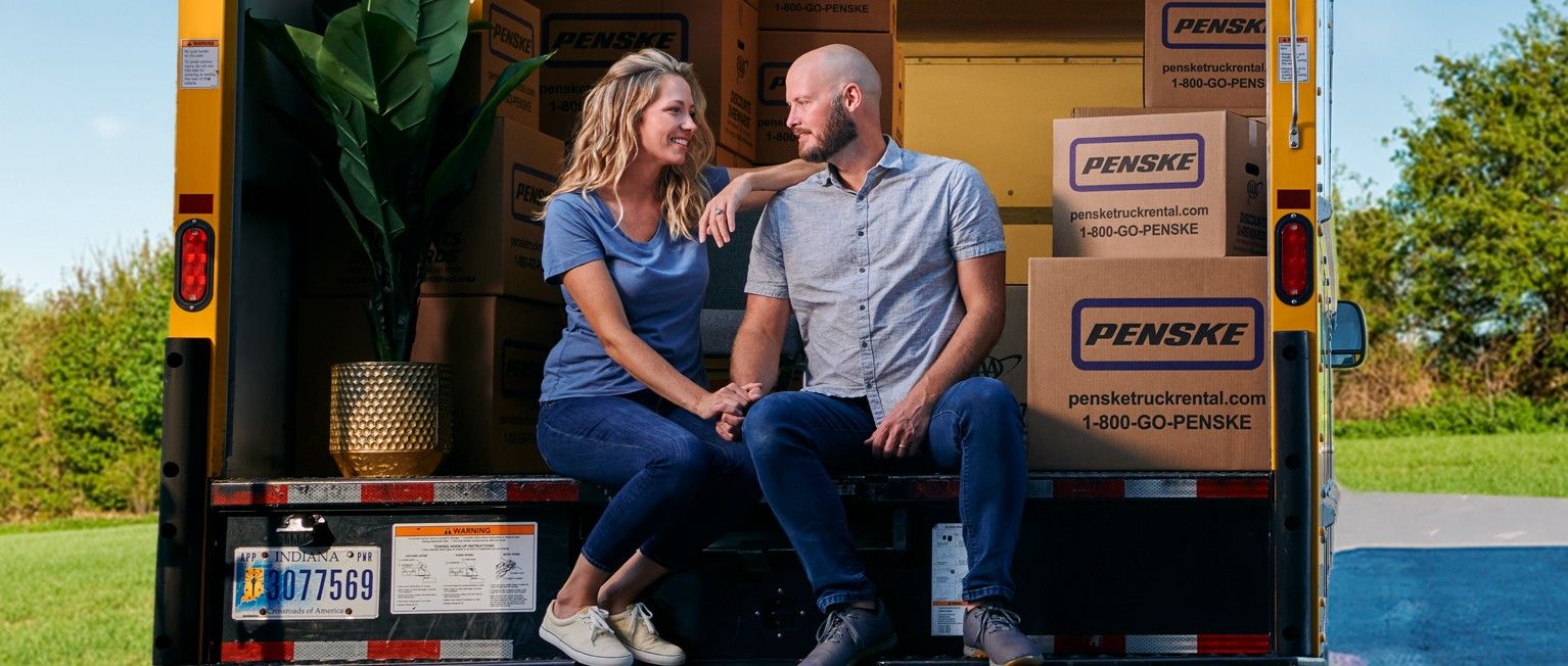 Happy couple with their moving truck rental