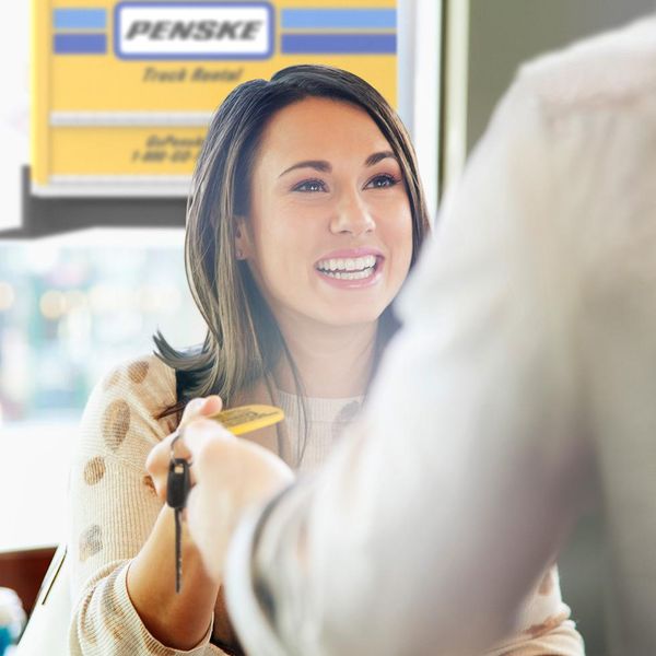 Happy customer receiving Penske rental keys at rental desk