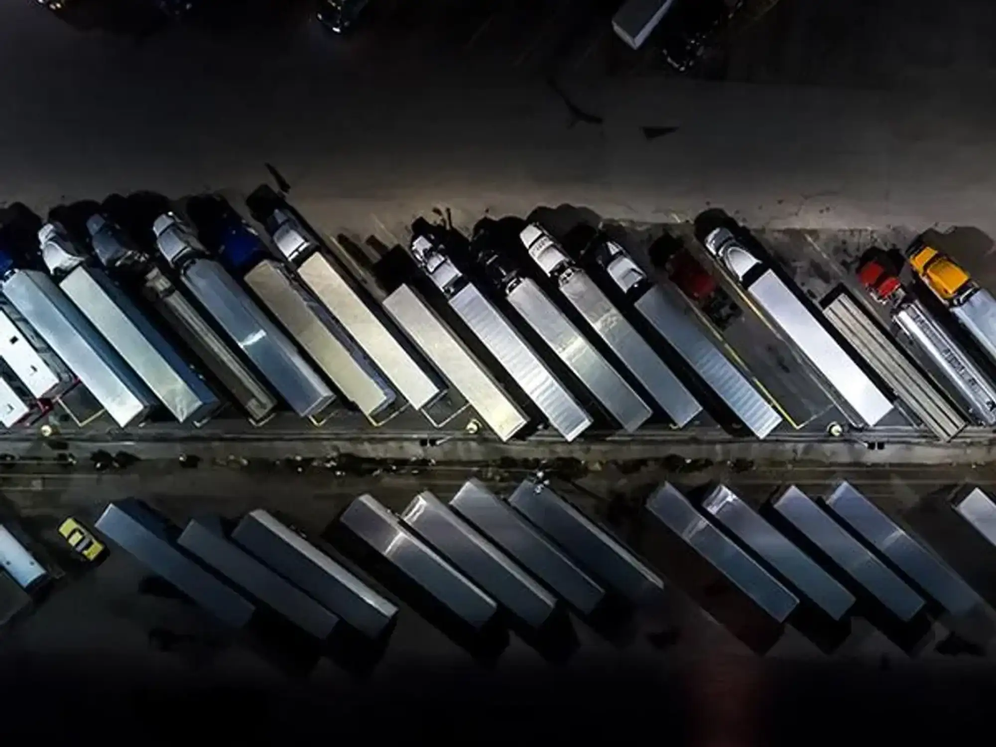 Many semi-trucks parked in a lot