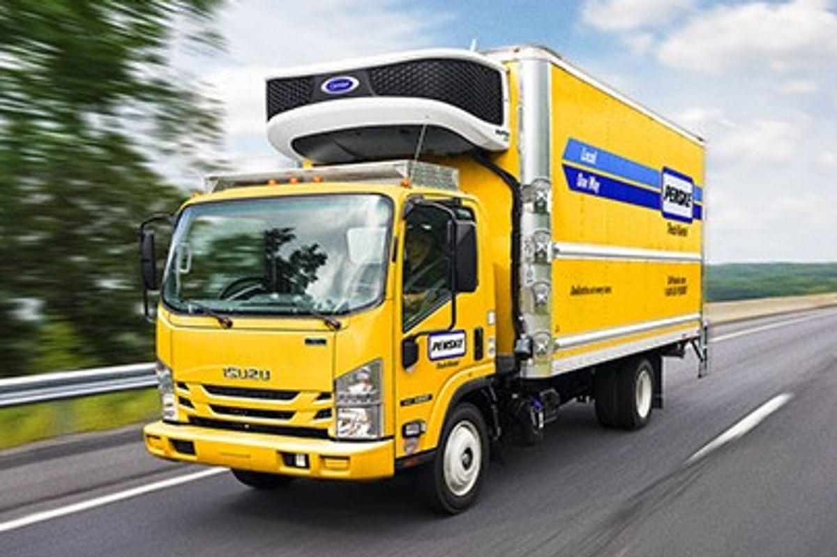 Penske cabover reefer truck on a tree-lined highway