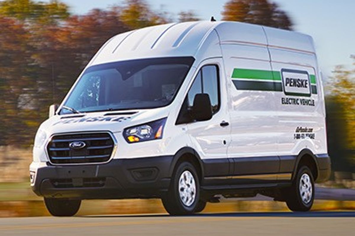 Penske electric cargo van on the highway surrounded by trees