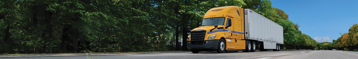 Penske tractor trailer along a tree-lined highway