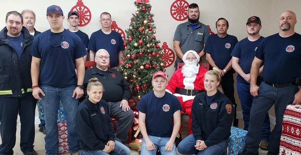 Pictured to the right of Santa is Penske associate Heather Bing and the local fire department.
