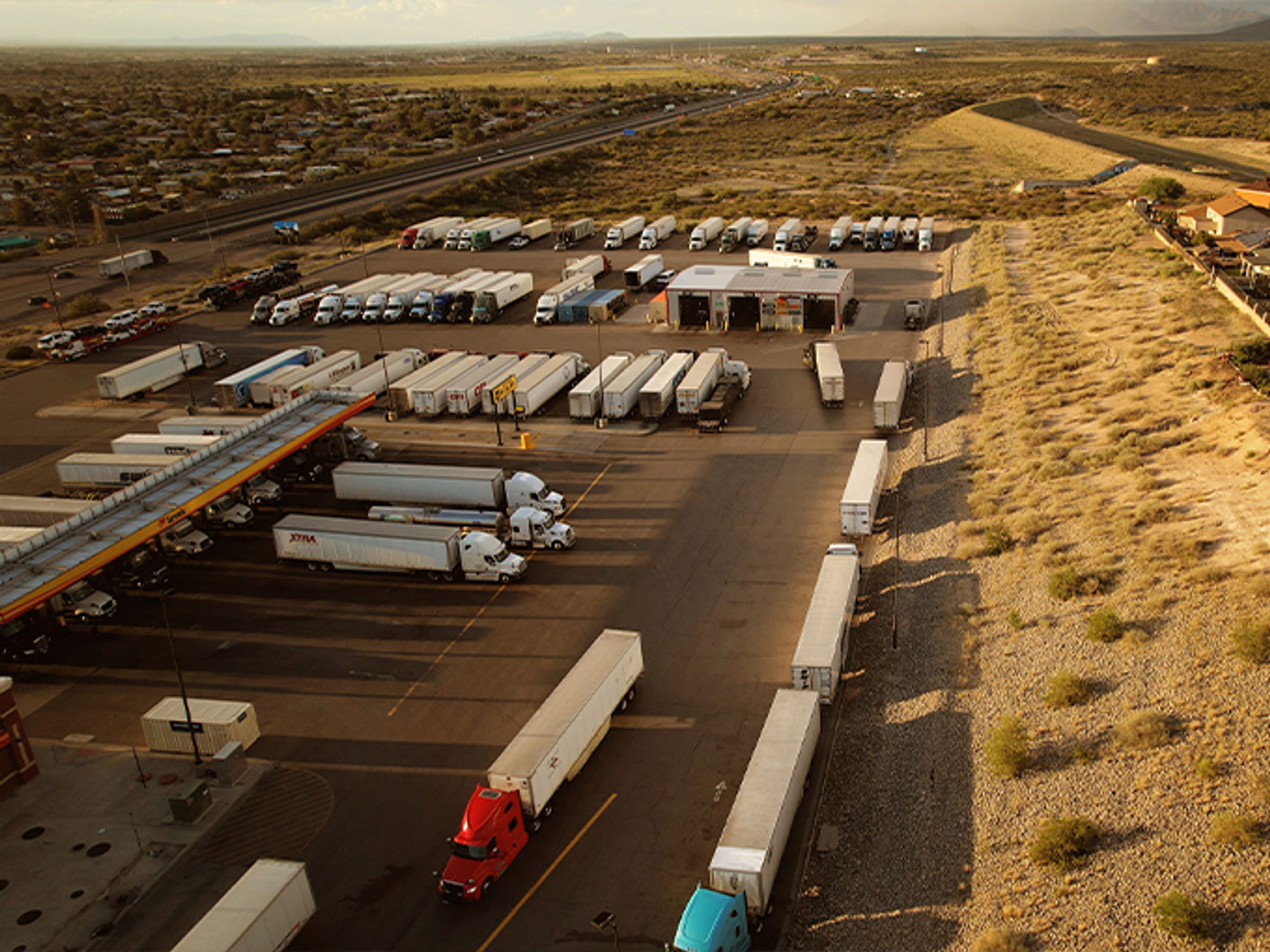 Semi-trucks park and get gas at a Texas roadside truck stop.