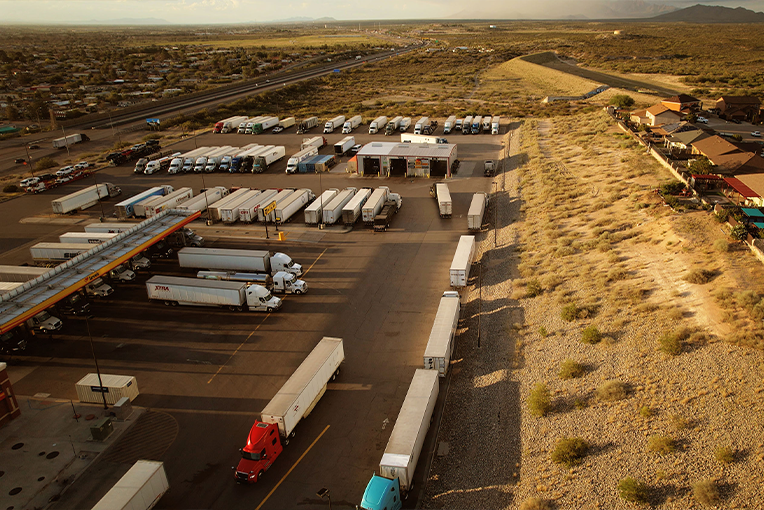 Semi-trucks park and get gas at a Texas roadside truck stop.