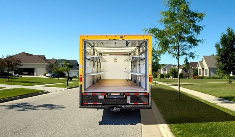 The inside of a Penske delivery truck with shelves.