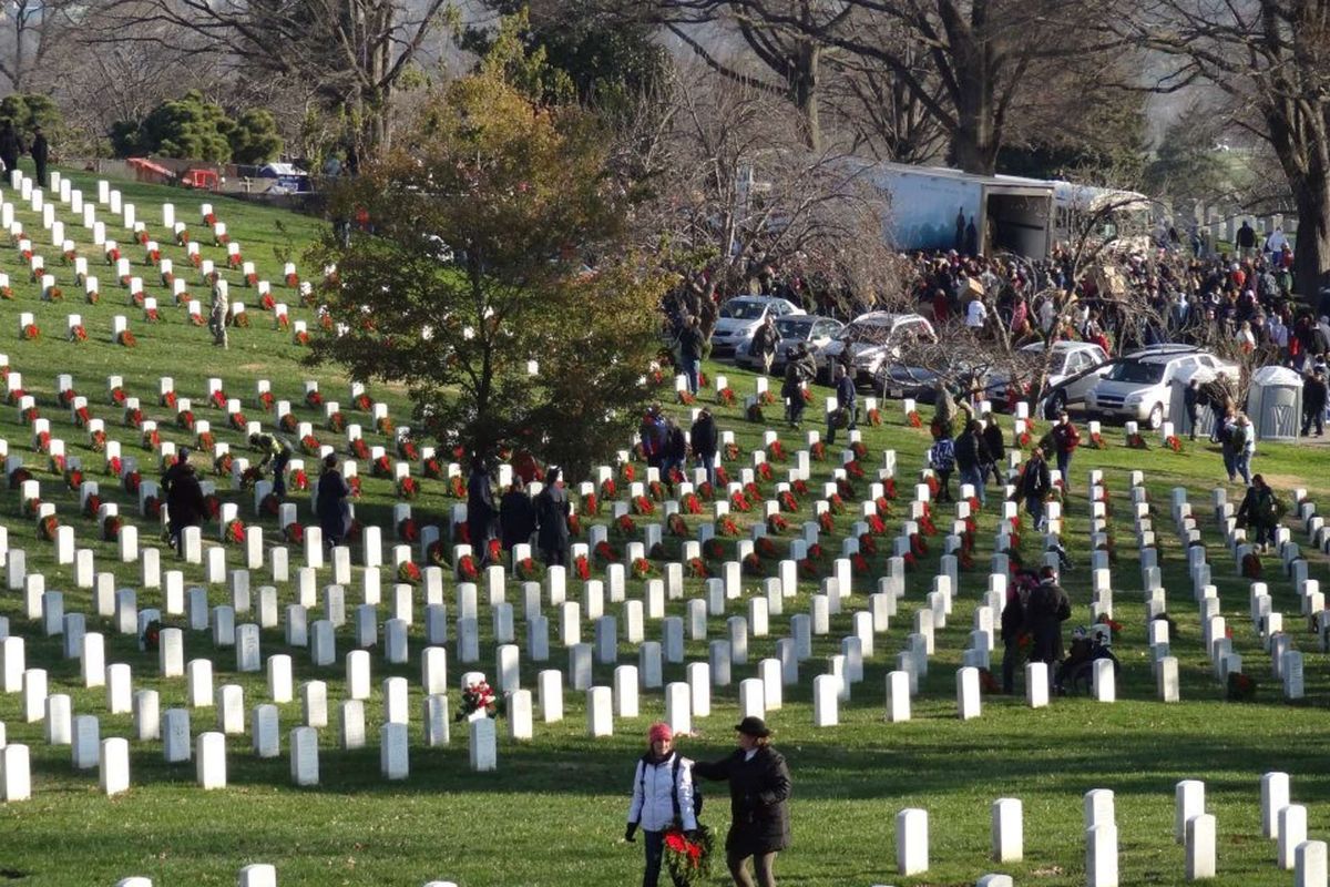 Two people lay wreaths at Arlington National Cemetery
