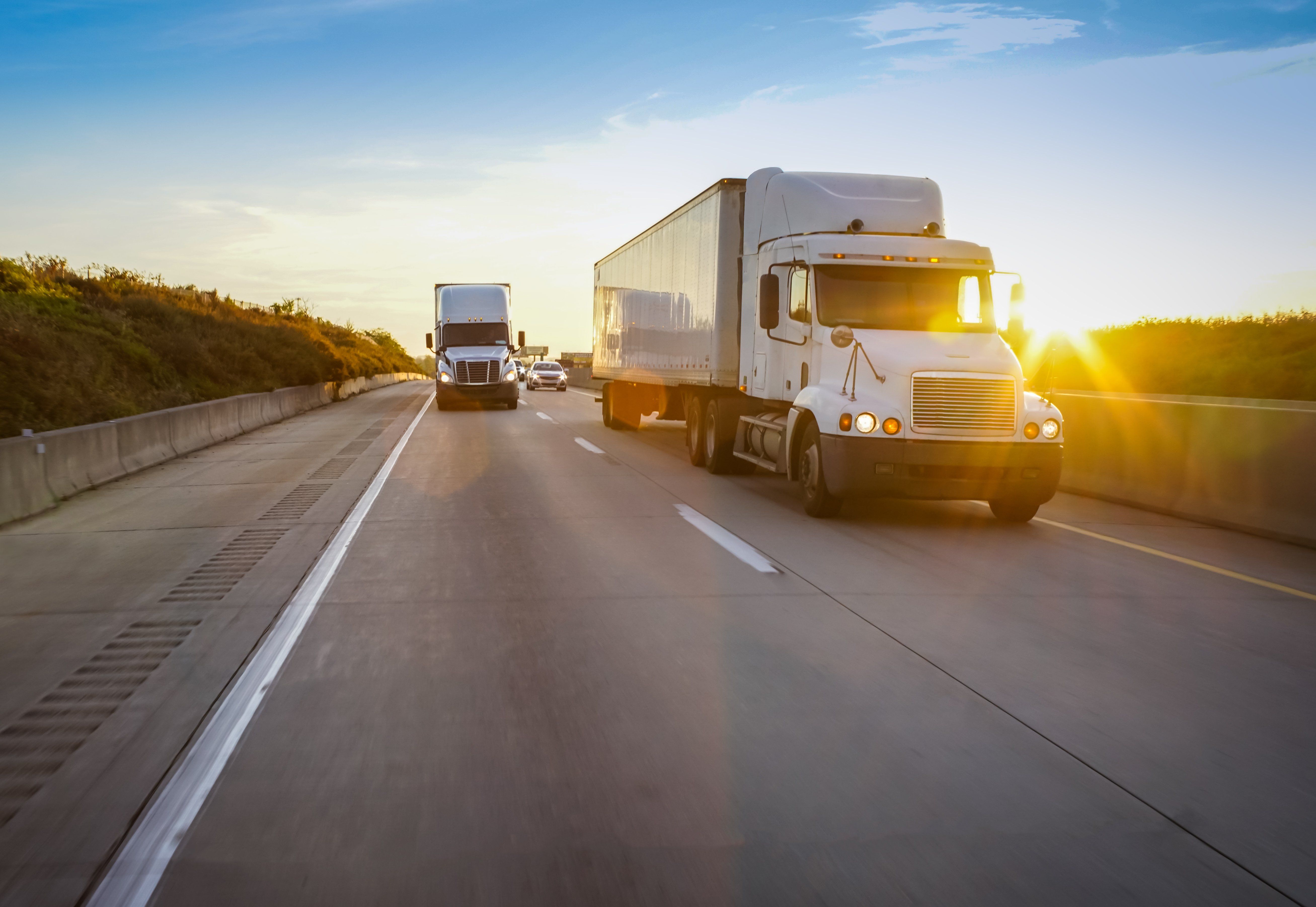 Two trucks driving on the road.