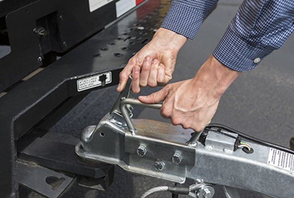 User connecting a tow dolly