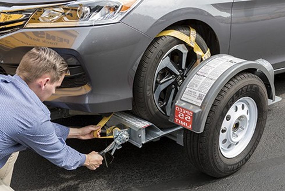 User connecting a tow dolly