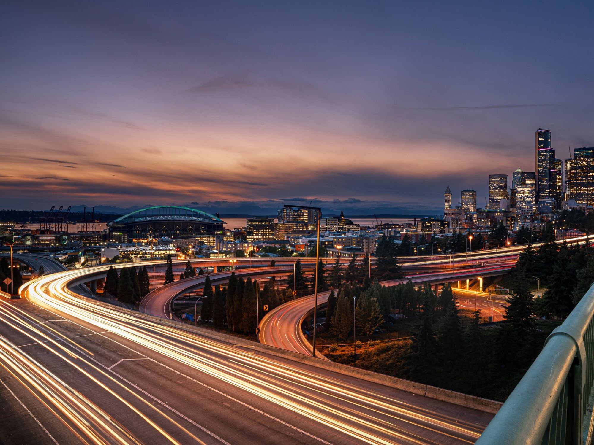 Vehicles speeding down a freeway outside a city at night