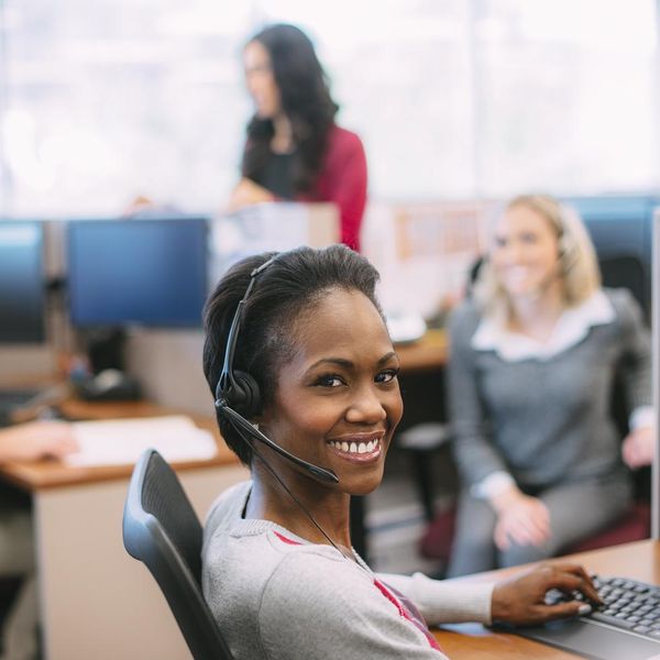 Woman sitting at desk with call center phone head set