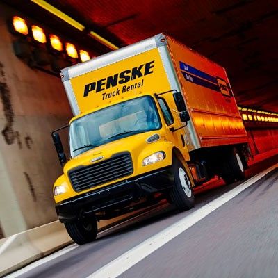 Yellow Penske truck driving through a tunnel