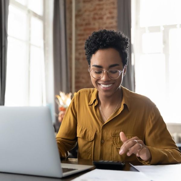 Young woman sitting at desk with laptop